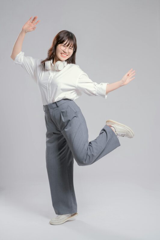Happy young woman dancing with headphones, expressing joy and freedom.